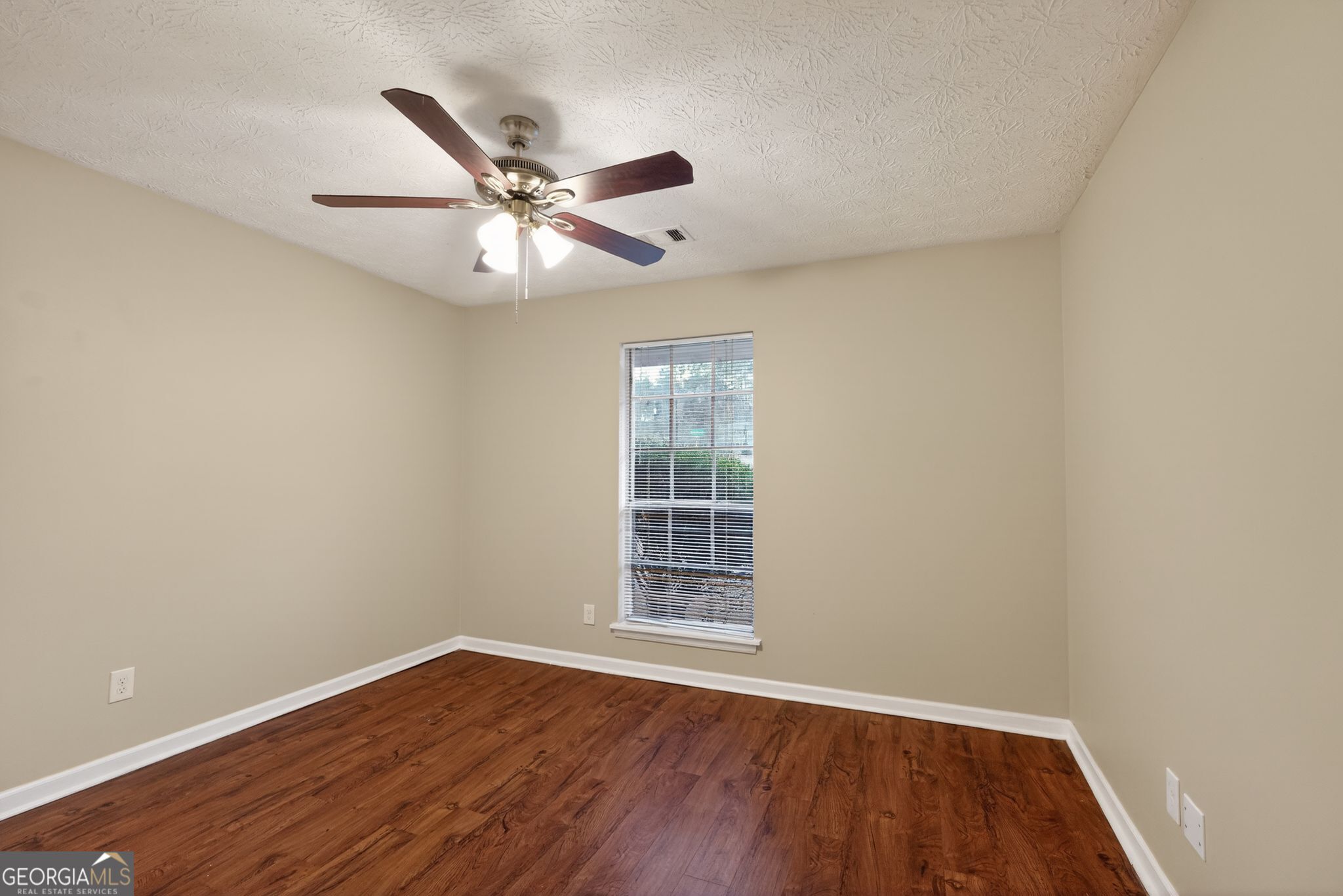 205 Whirlwind Court Atlanta, GA 30349 - Photo 16 of 32 an empty room with wooden floor ceiling fan and windows