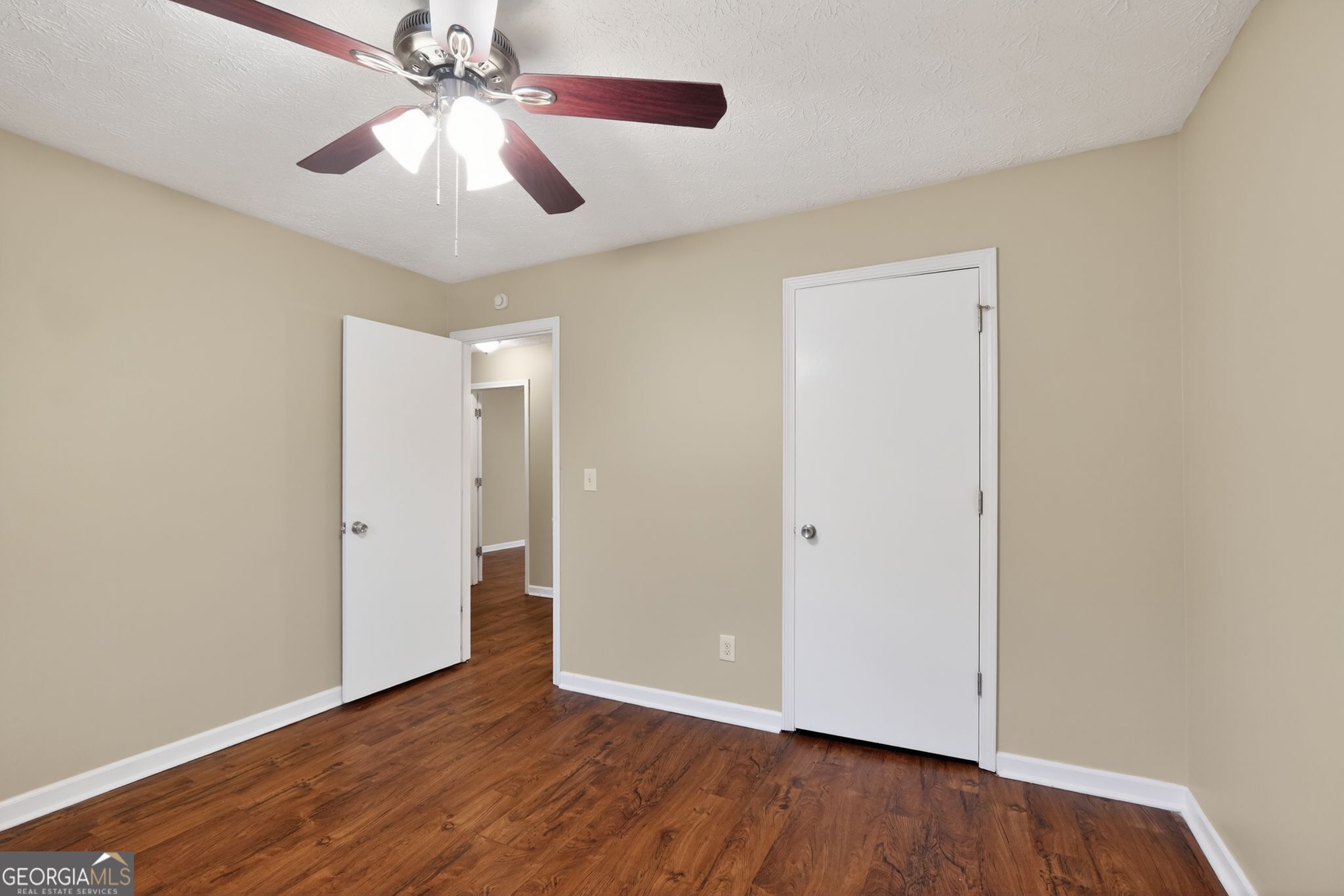205 Whirlwind Court Atlanta, GA 30349 - Photo 22 of 32 an empty room with wooden floor chandelier fan and closet area