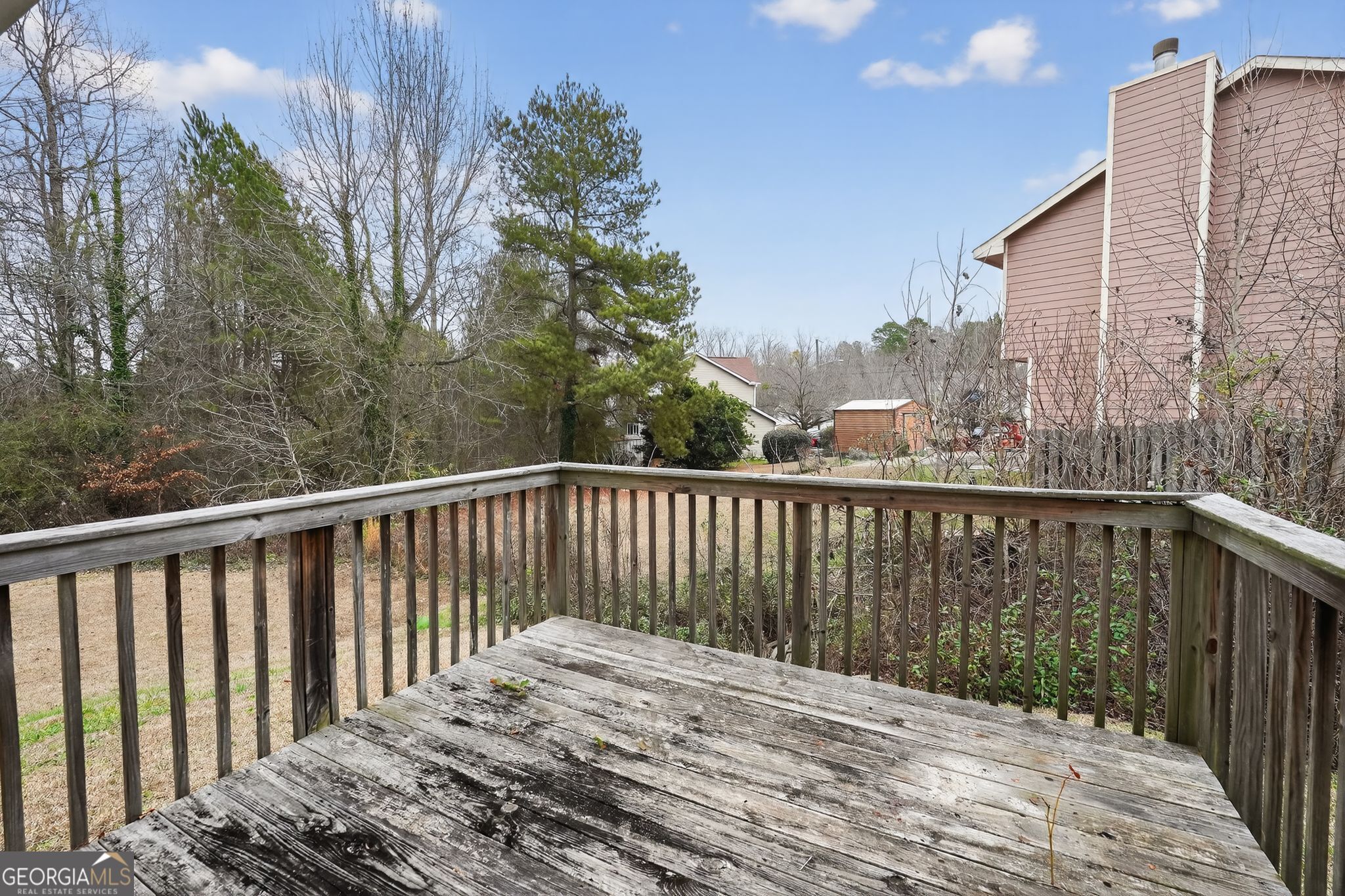 205 Whirlwind Court Atlanta, GA 30349 - Photo 31 of 32 a balcony with wooden floor and fence