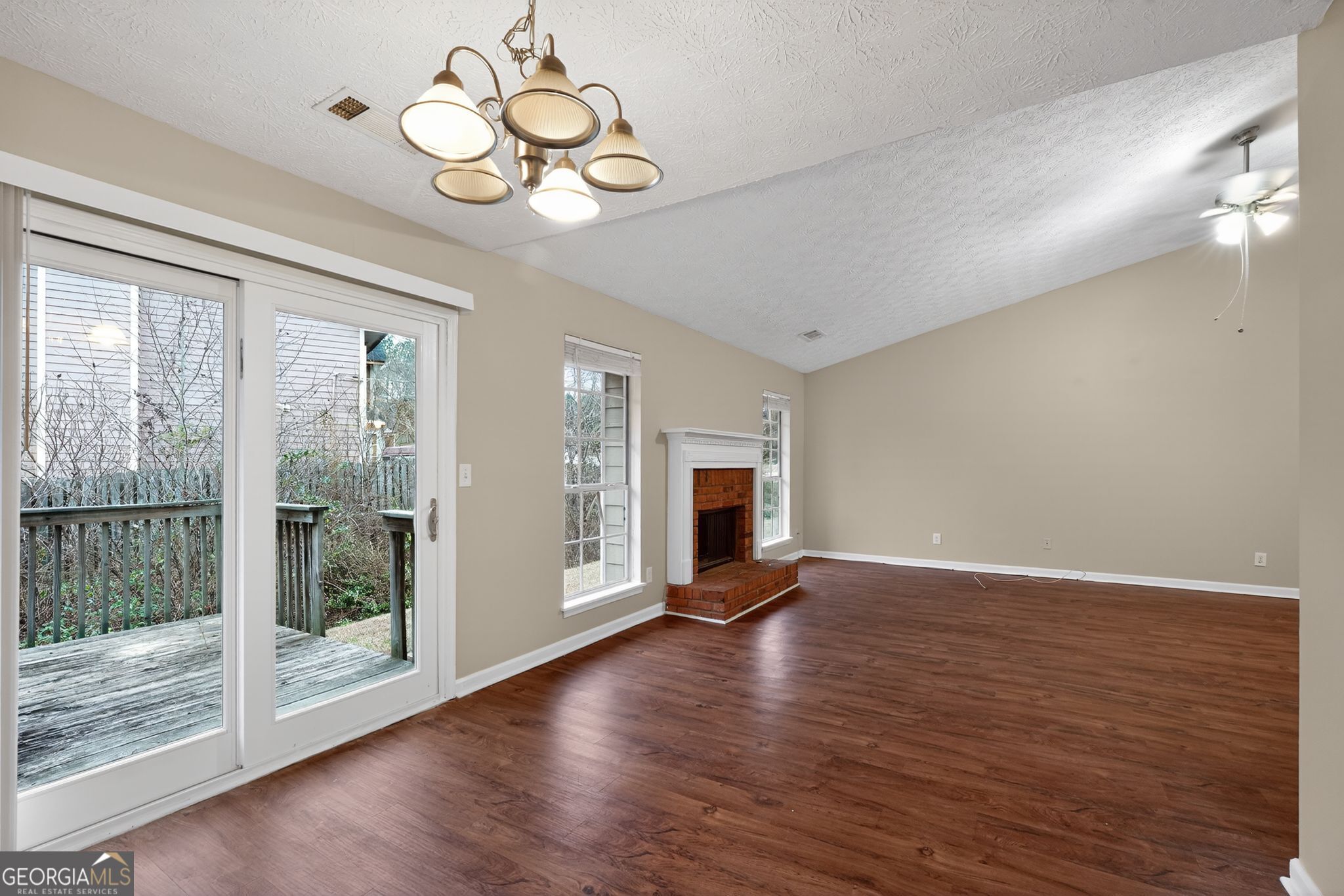 205 Whirlwind Court Atlanta, GA 30349 - Photo 8 of 32 a view of an empty room with wooden floor and a window