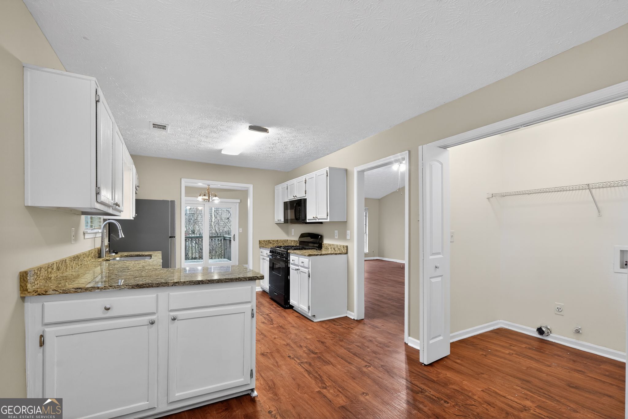 205 Whirlwind Court Atlanta, GA 30349 - Photo 10 of 32 a kitchen with granite countertop a refrigerator stove and sink