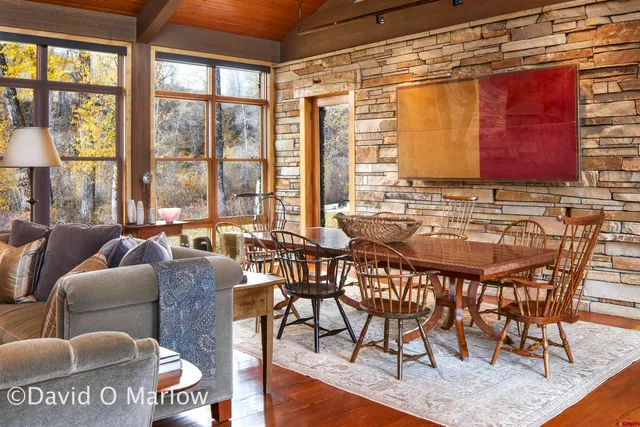 a dining room with furniture a chandelier and wooden floor