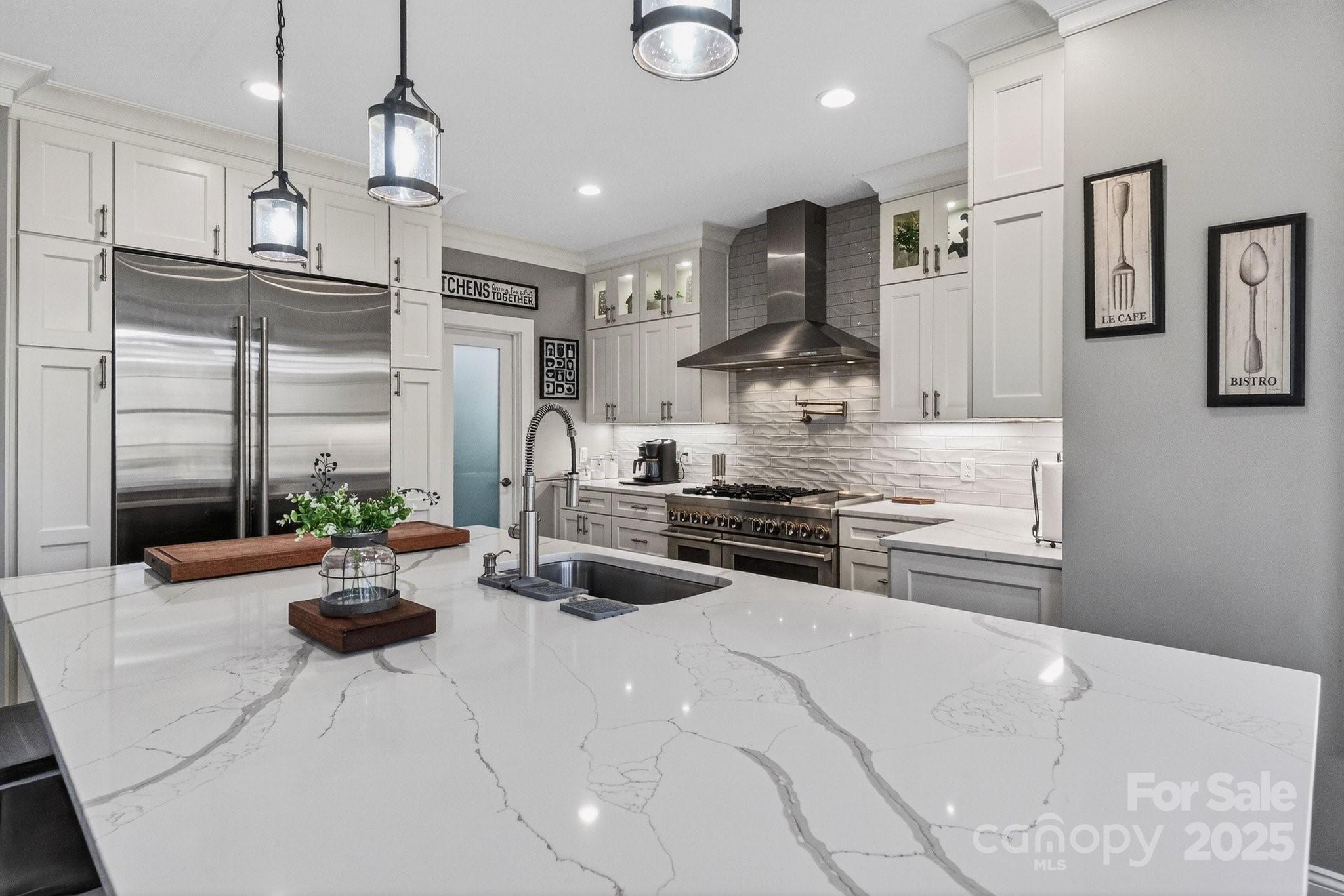 7653 Juniper Lane Denver, NC 28037 - Photo 11 of 43 a kitchen with stainless steel appliances a stove a sink a oven a dining table and chairs