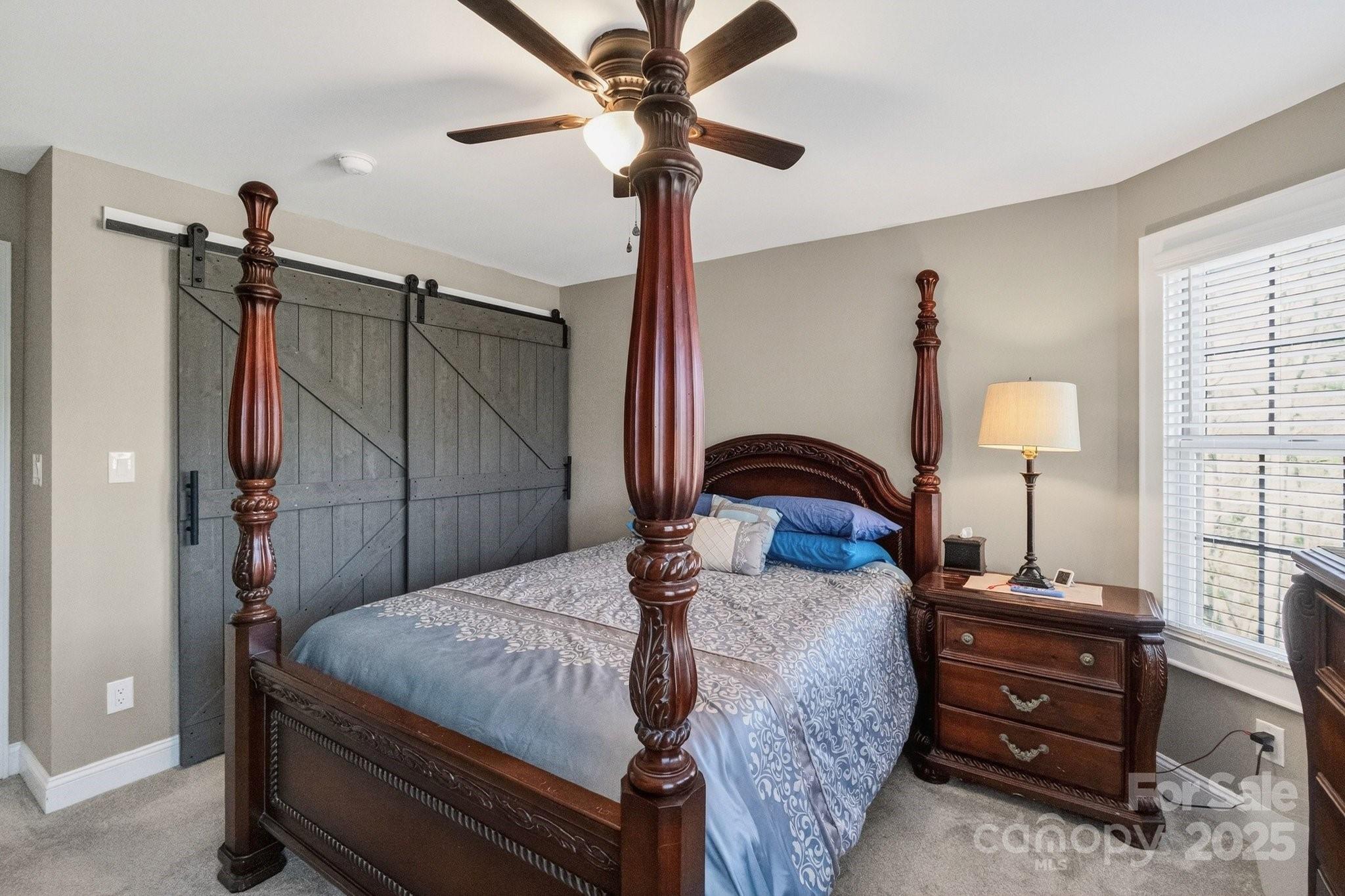7653 Juniper Lane Denver, NC 28037 - Photo 29 of 43 a bedroom with a bed and a chandelier