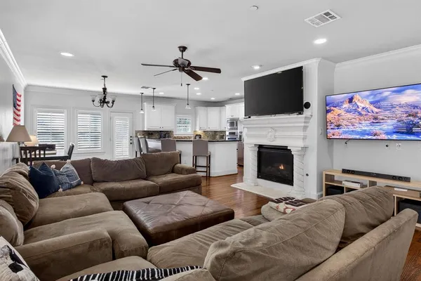 a living room with furniture a flat screen tv and a fireplace