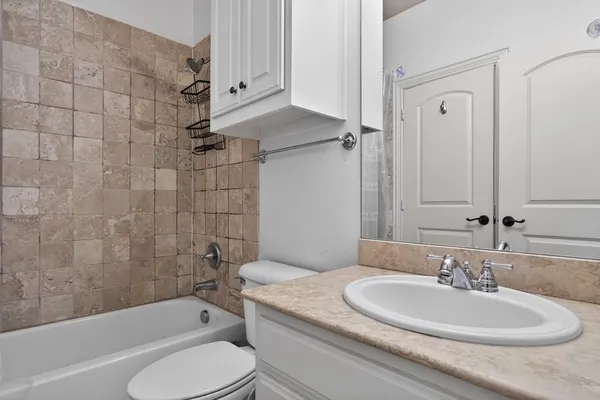 a bathroom with a granite countertop sink toilet and shower