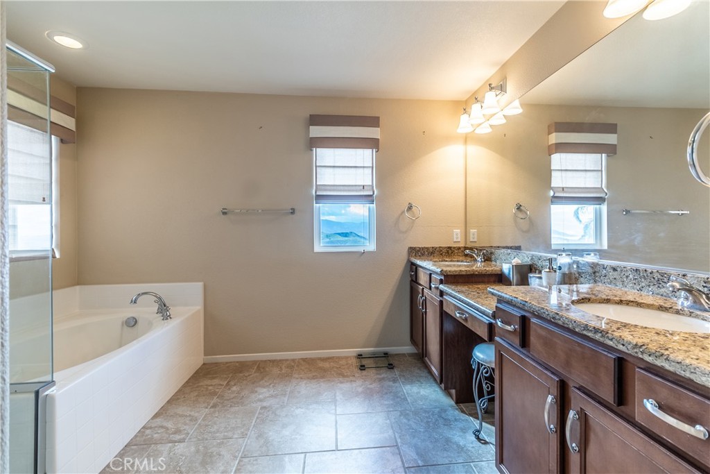 16657 Golden Bluff Loop Riverside, CA 92503 - Photo 30 of 47 a spacious bathroom with a granite countertop sink a mirror and a bathtub