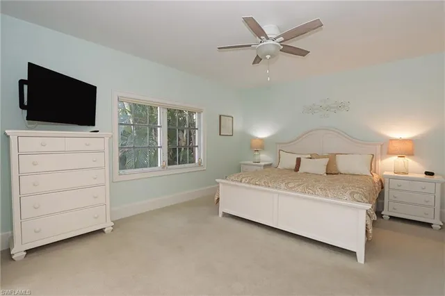 a bedroom with a large bed and a flat tv screen on dresser