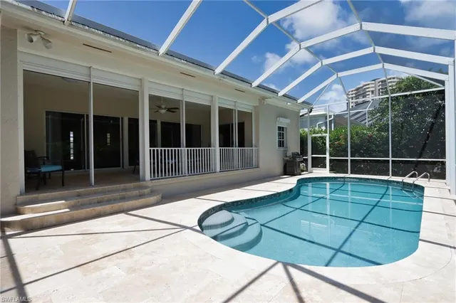 a view of a backyard with table and chairs under an umbrella