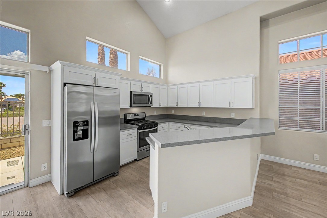 2316 Ramsgate Drive Henderson, NV 89074 - Photo 9 of 28 A well-lit kitchen with soaring vaulted ceilings, sleek countertops, and modern appliances.