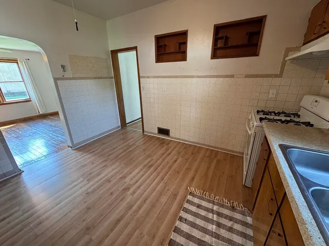 a view of a kitchen with wooden floor and staircase