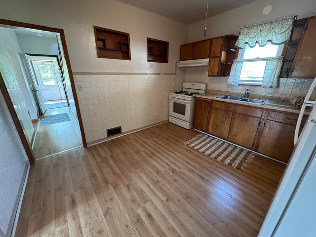 a kitchen with wooden floors and a white stove