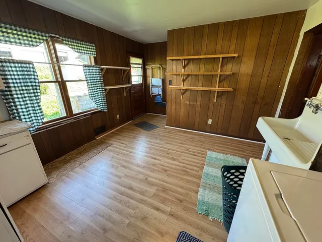 a view of an empty room with wooden floor and windows