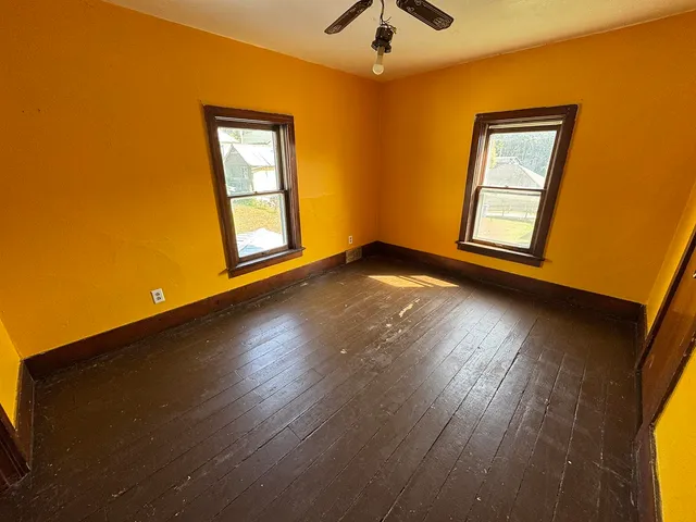 a view of a room with wooden floor and a ceiling fan