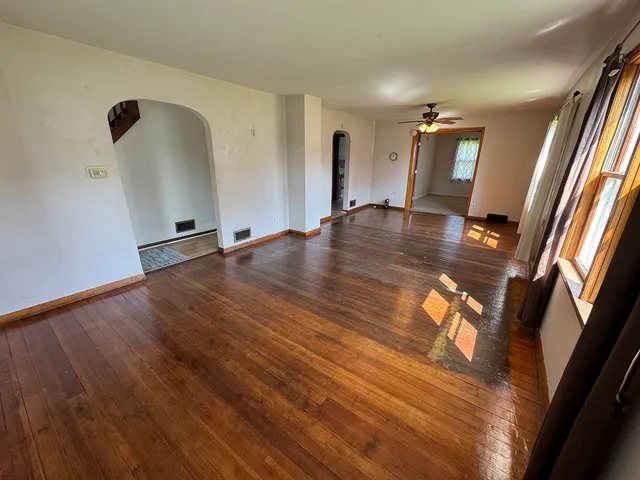 a view of a livingroom with wooden floor and staircase