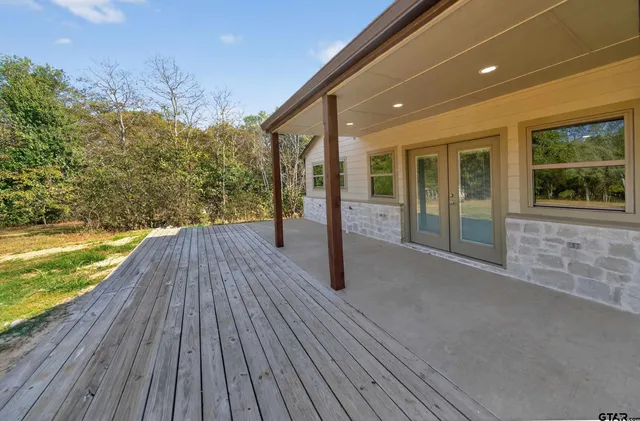 a view of a lake with a yard and trees in the background