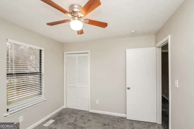 a view of a livingroom with a ceiling fan and window