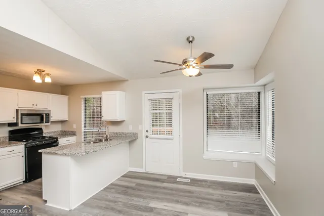 a view of kitchen with sink microwave and refrigerator