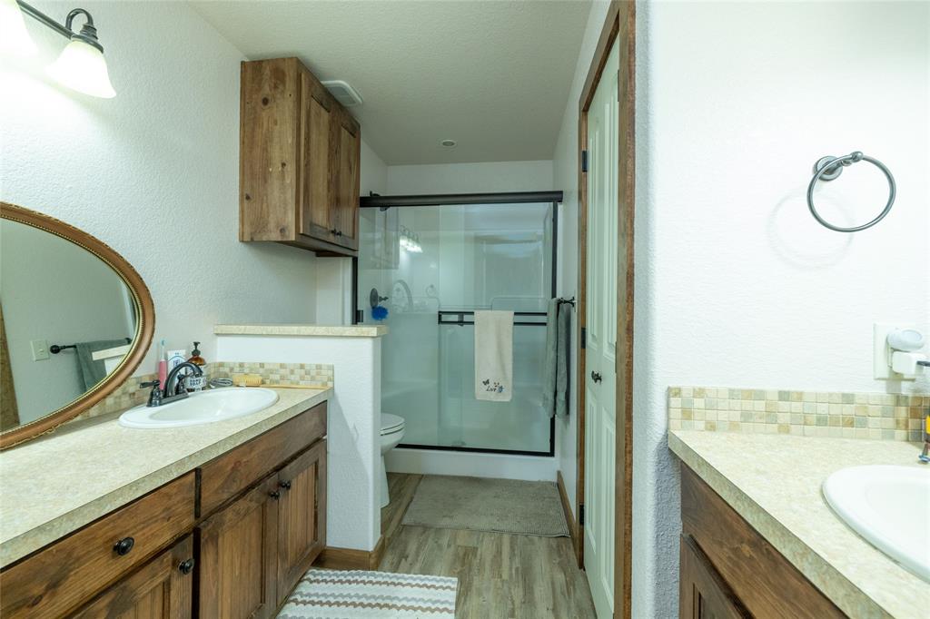 493 Browning Road Bellevue, TX 76228 - Photo 11 of 33 a bathroom with a granite countertop sink and a mirror