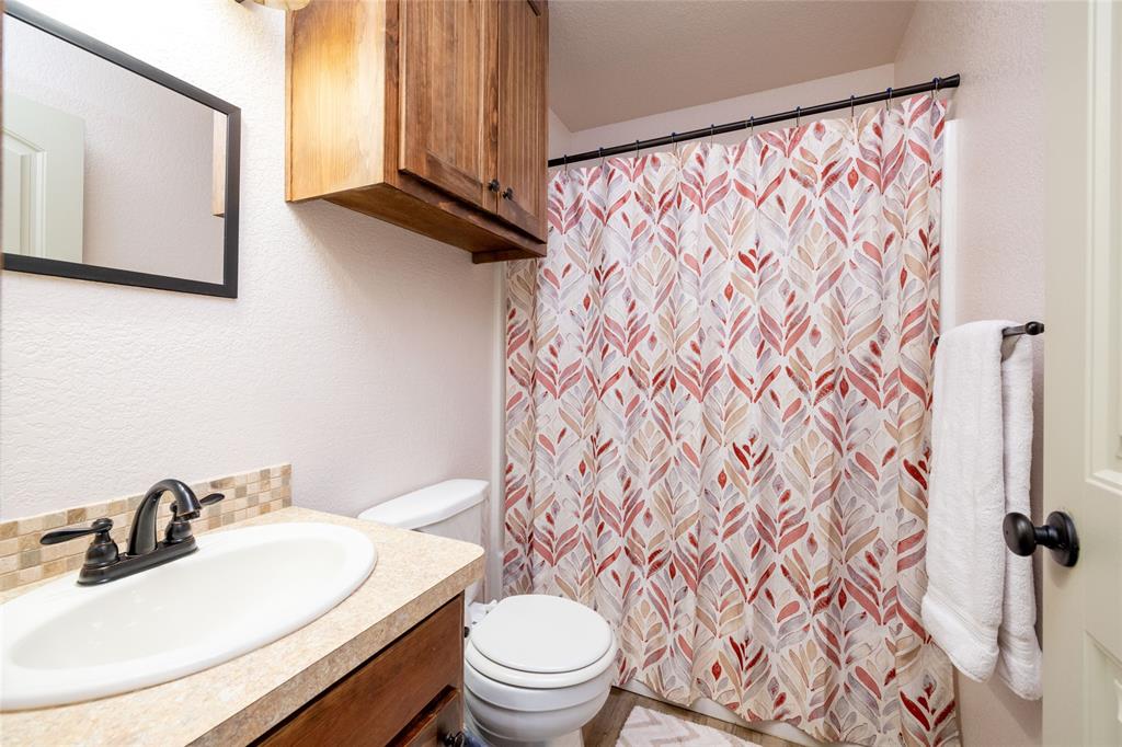 493 Browning Road Bellevue, TX 76228 - Photo 14 of 33 a bathroom with a sink toilet and a mirror
