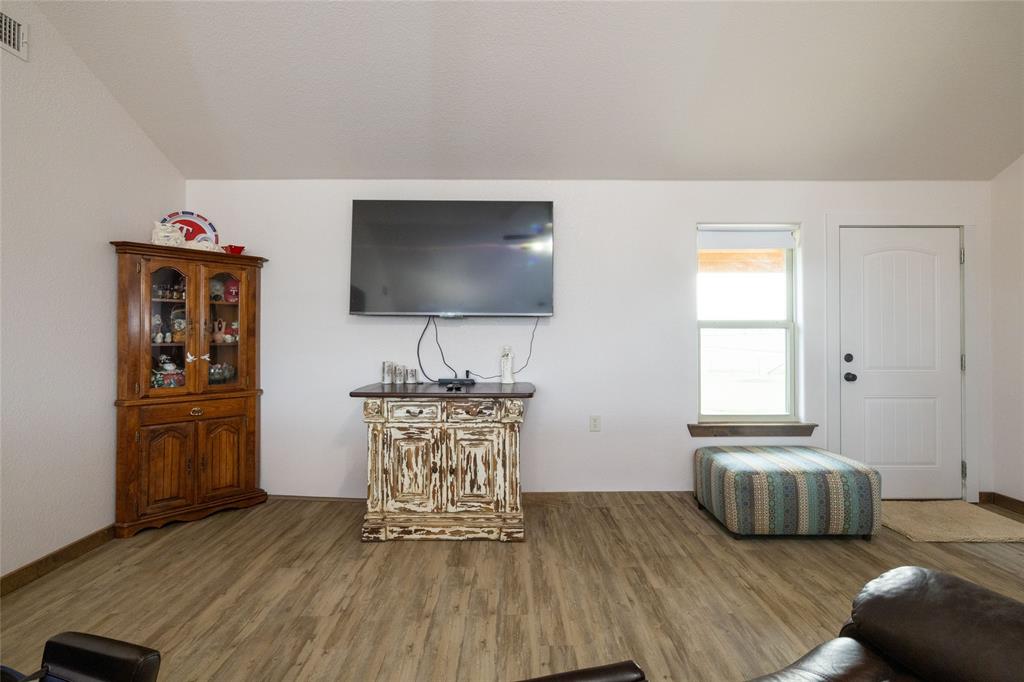 493 Browning Road Bellevue, TX 76228 - Photo 2 of 33 a living room with furniture and a flat screen tv