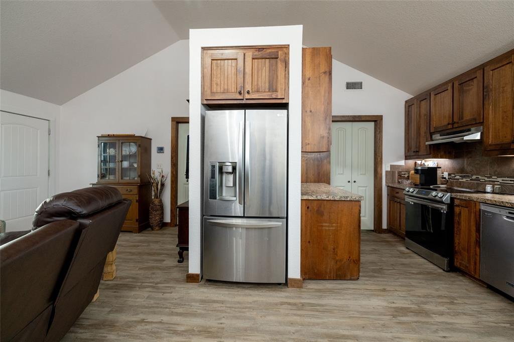 493 Browning Road Bellevue, TX 76228 - Photo 5 of 33 a kitchen with granite countertop stainless steel appliances a refrigerator a stove a cabinets and a refrigerator
