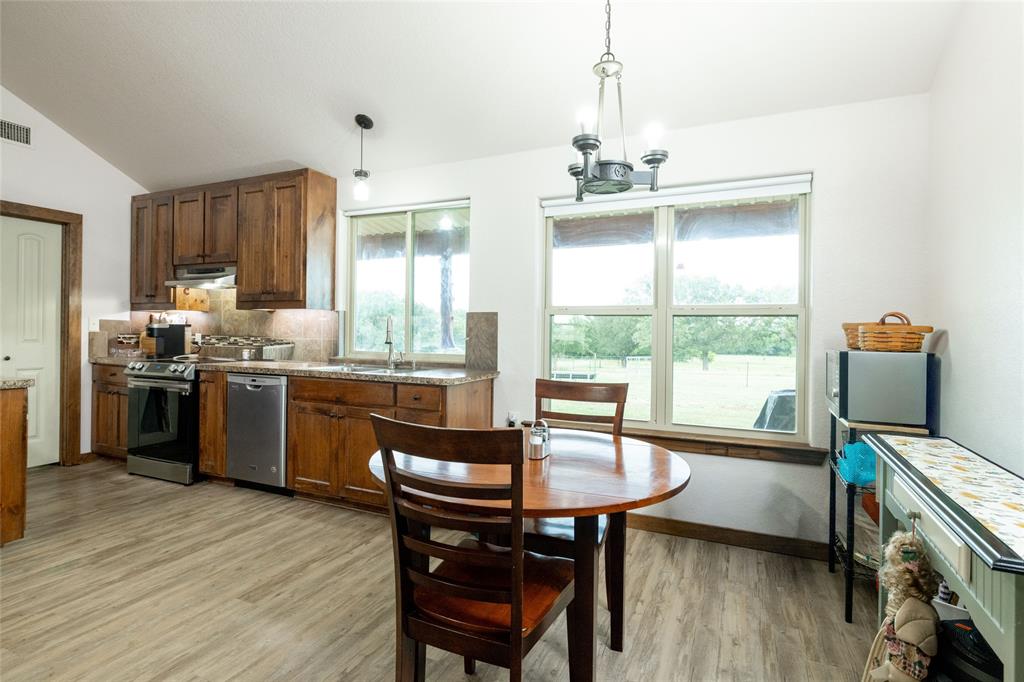 493 Browning Road Bellevue, TX 76228 - Photo 9 of 33 a kitchen with a table chairs a sink dishwasher window and cabinets