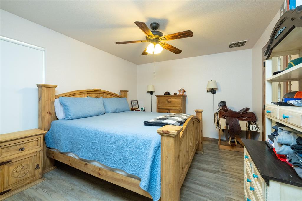493 Browning Road Bellevue, TX 76228 - Photo 10 of 33 a bed room with a bed and a chandelier