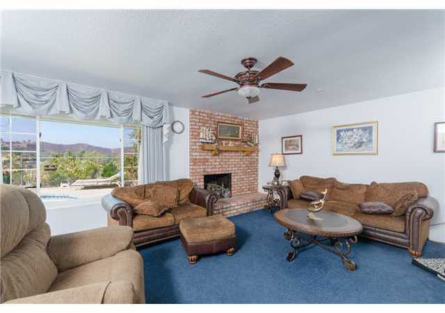 8859 Los Coches Road Lakeside, CA 92040 - Photo 10 of 25 The spacious living room has an inviting fireplace for those cold winter nights and a picture window looking out to the pool and the mountains beyond..