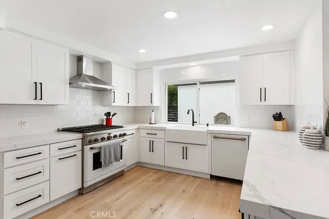 a kitchen with white cabinets and white appliances