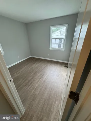 a view of a room with wooden floor and window