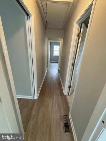 a view of a hallway with wooden floor and stairs