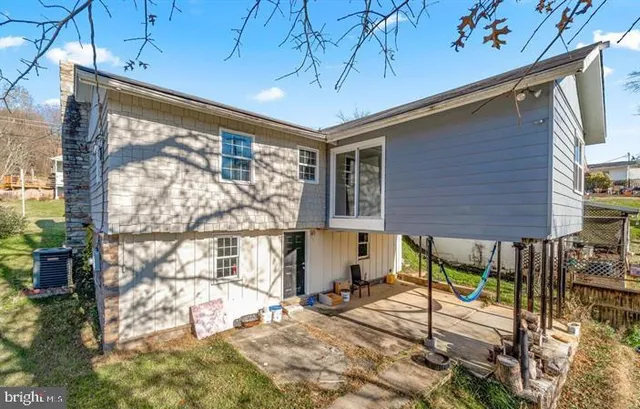 a patio with table and chairs and potted plants