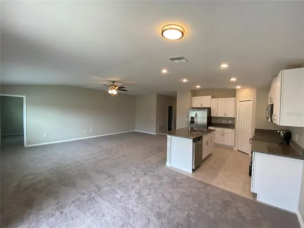 a kitchen with stainless steel appliances granite countertop a sink a stove and a refrigerator