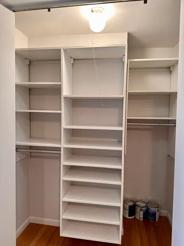 a view of walk in closet with empty racks