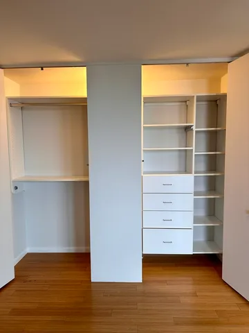 a view of an empty room with a wooden floor and a window
