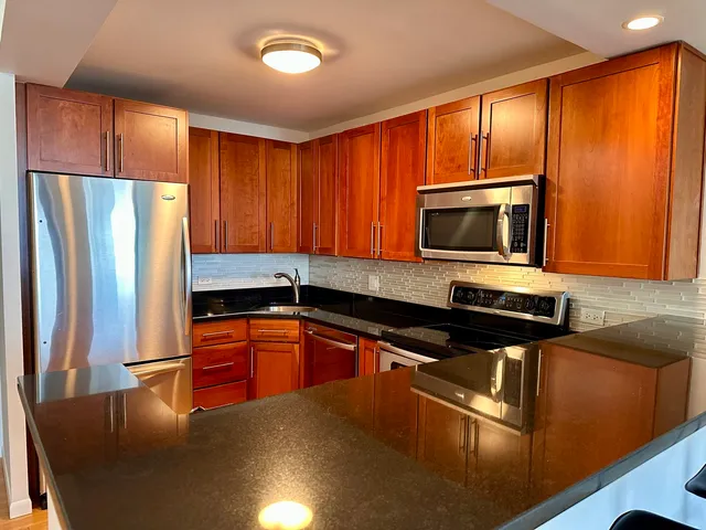 a kitchen with stainless steel appliances granite countertop a refrigerator stove microwave and sink