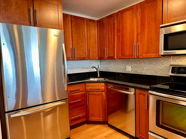 a kitchen with stainless steel appliances granite countertop a refrigerator and a sink