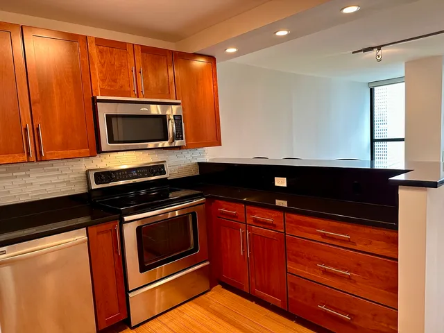 a kitchen with wooden cabinets and stainless steel appliances