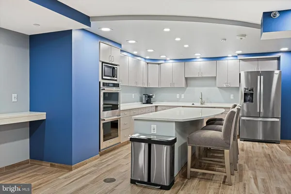 a kitchen with kitchen island stainless steel appliances a sink and counter space