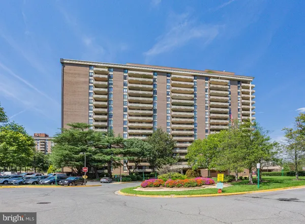 a front view of a building with cars parked