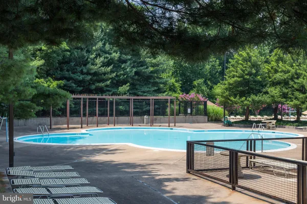 a view of a swimming pool with a yard and sitting area