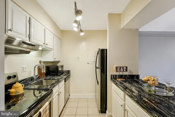 a kitchen with stainless steel appliances granite countertop a stove and a refrigerator