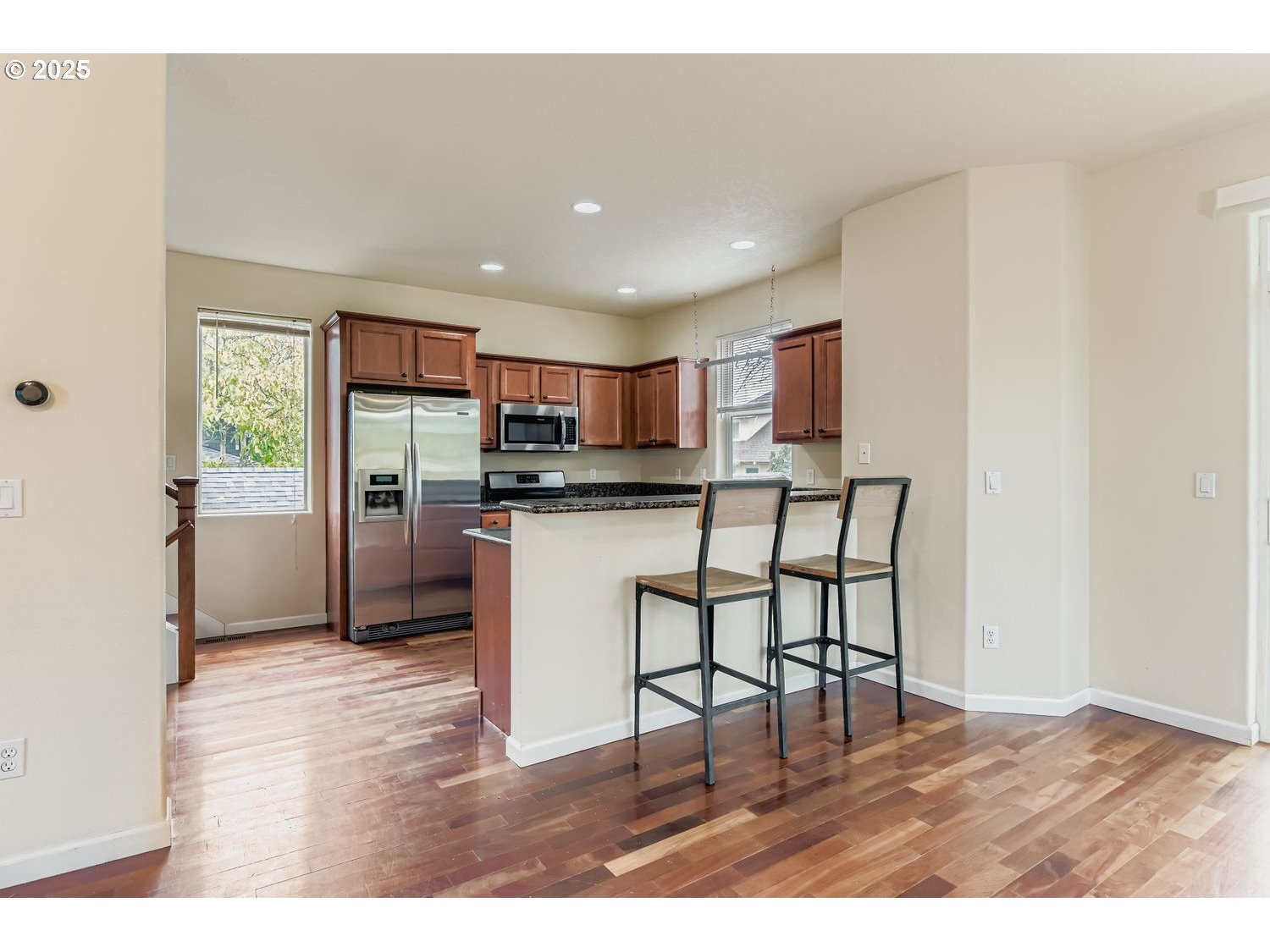 7912 Northeast Klickitat Street Portland, OR 97213 - Photo 11 of 29 a kitchen with stainless steel appliances kitchen island granite countertop a refrigerator a stove a sink and a dining table with wooden floor