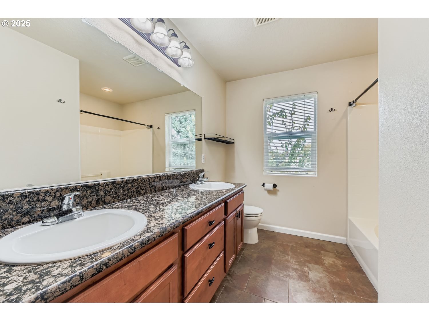 7912 Northeast Klickitat Street Portland, OR 97213 - Photo 16 of 29 a bathroom with a granite countertop sink a mirror a vanity and shower