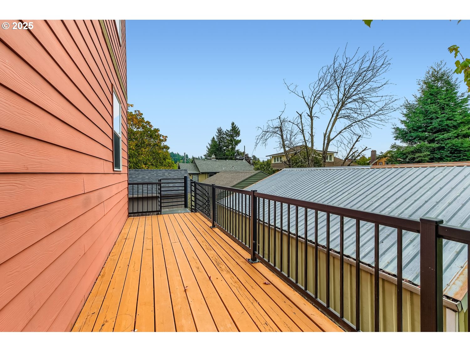 7912 Northeast Klickitat Street Portland, OR 97213 - Photo 23 of 29 a balcony with wooden floor and trees in the back