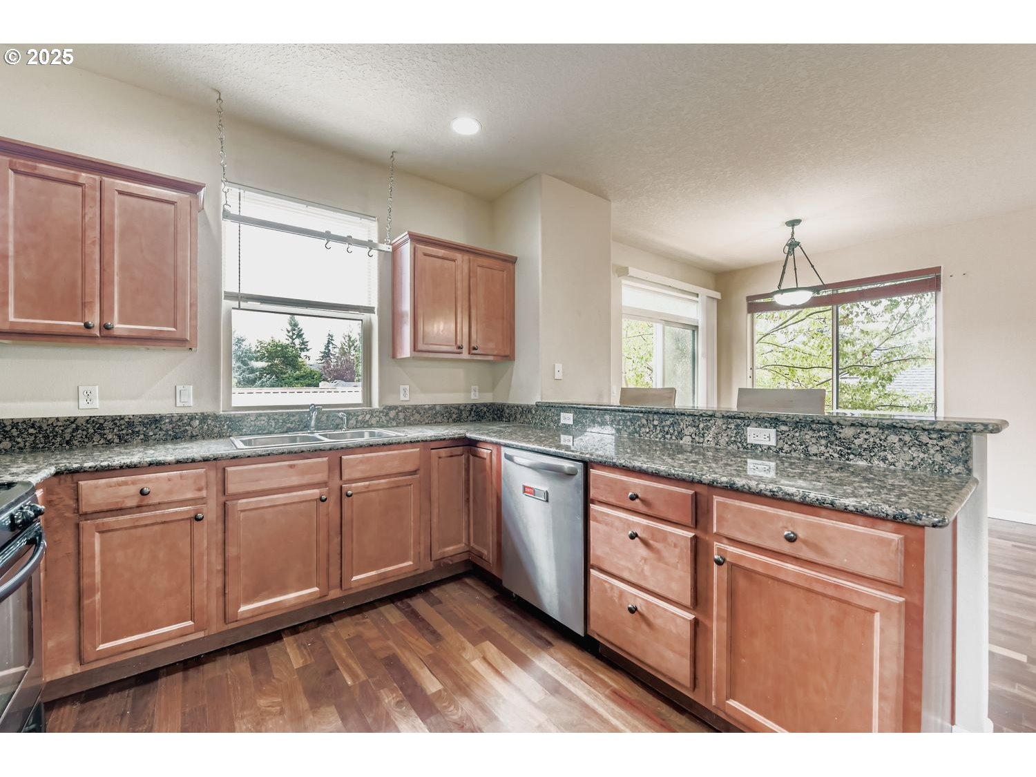 7912 Northeast Klickitat Street Portland, OR 97213 - Photo 9 of 29 a kitchen with granite countertop wooden cabinets a sink and dishwasher with wooden floor