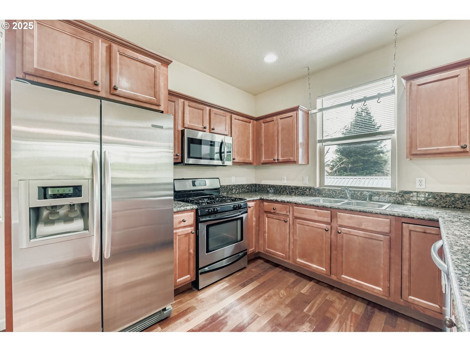 7912 Northeast Klickitat Street Portland, OR 97213 - Photo 10 of 29 a kitchen with stainless steel appliances granite countertop a refrigerator a stove a sink and a microwave