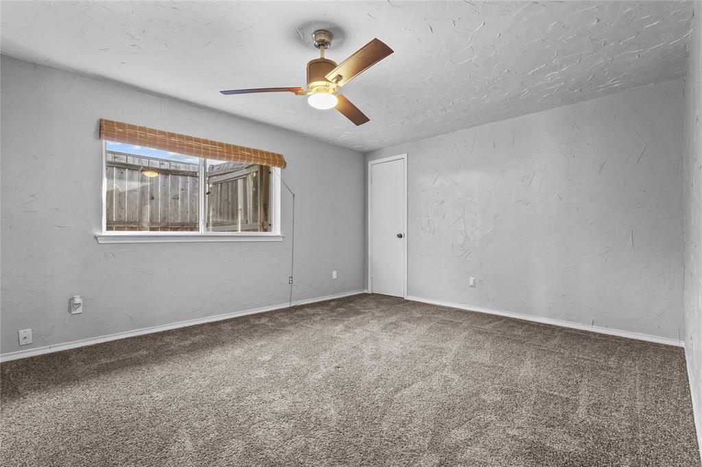 12218 Treeview Lane Farmers Branch, TX 75234 - Photo 12 of 17 an empty room with windows and fan