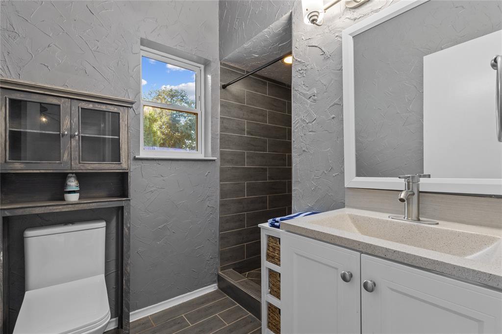 12218 Treeview Lane Farmers Branch, TX 75234 - Photo 15 of 17 a bathroom with a sink a toilet and shower